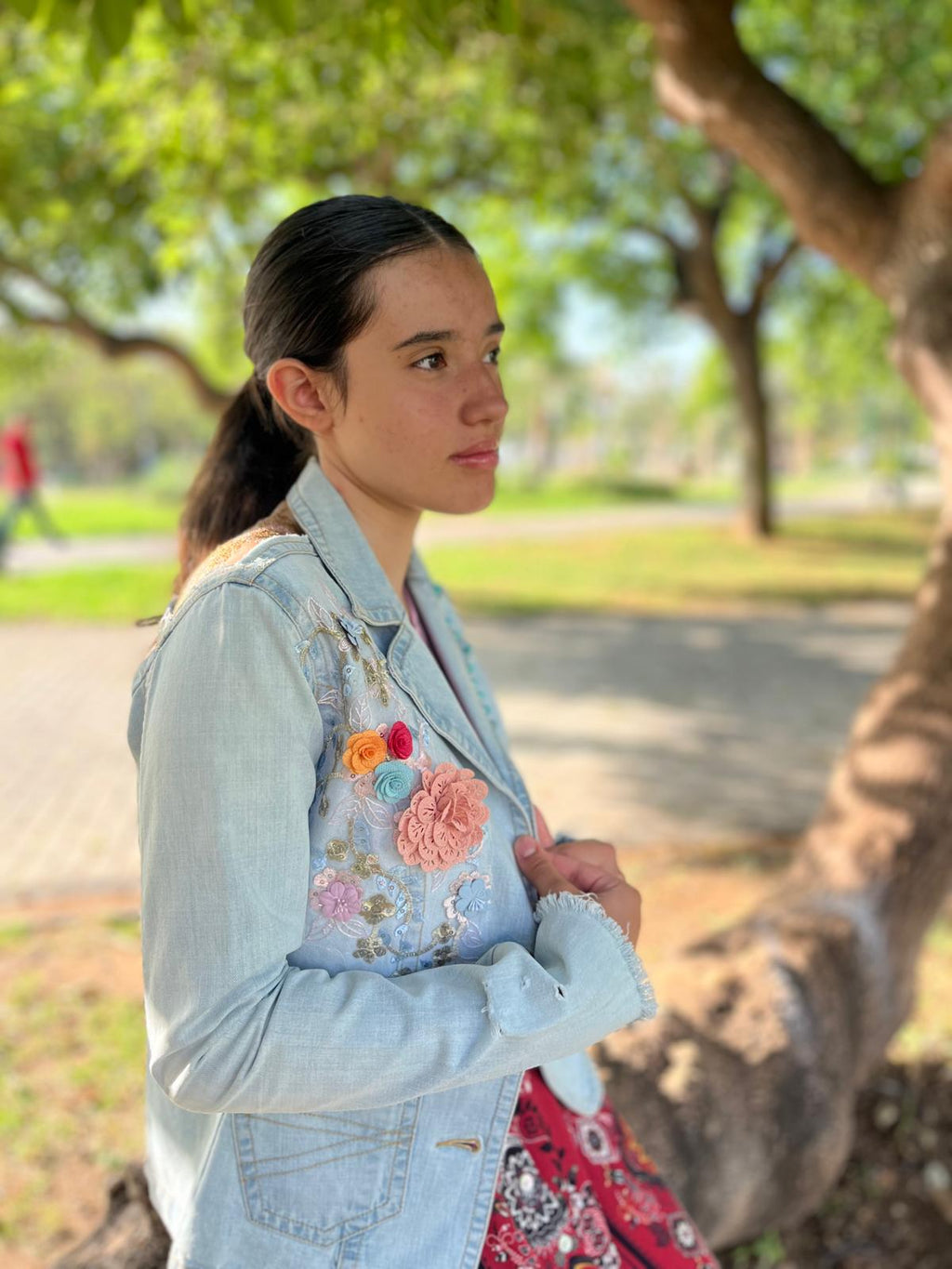 Chaqueta Bruma en denim claro, con flores bordadas sobre tul, tachuelas y encaje antiguo cosido a mano en la espalda.