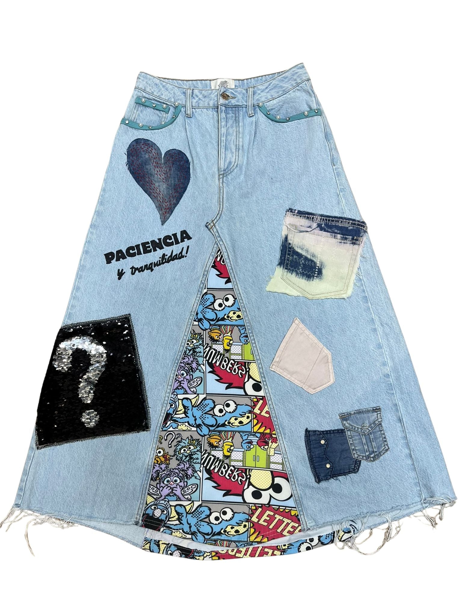 “Falda Hilena de denim reciclado con pedrería, frase pintada a mano y parche de lentejuelas reversibles.”